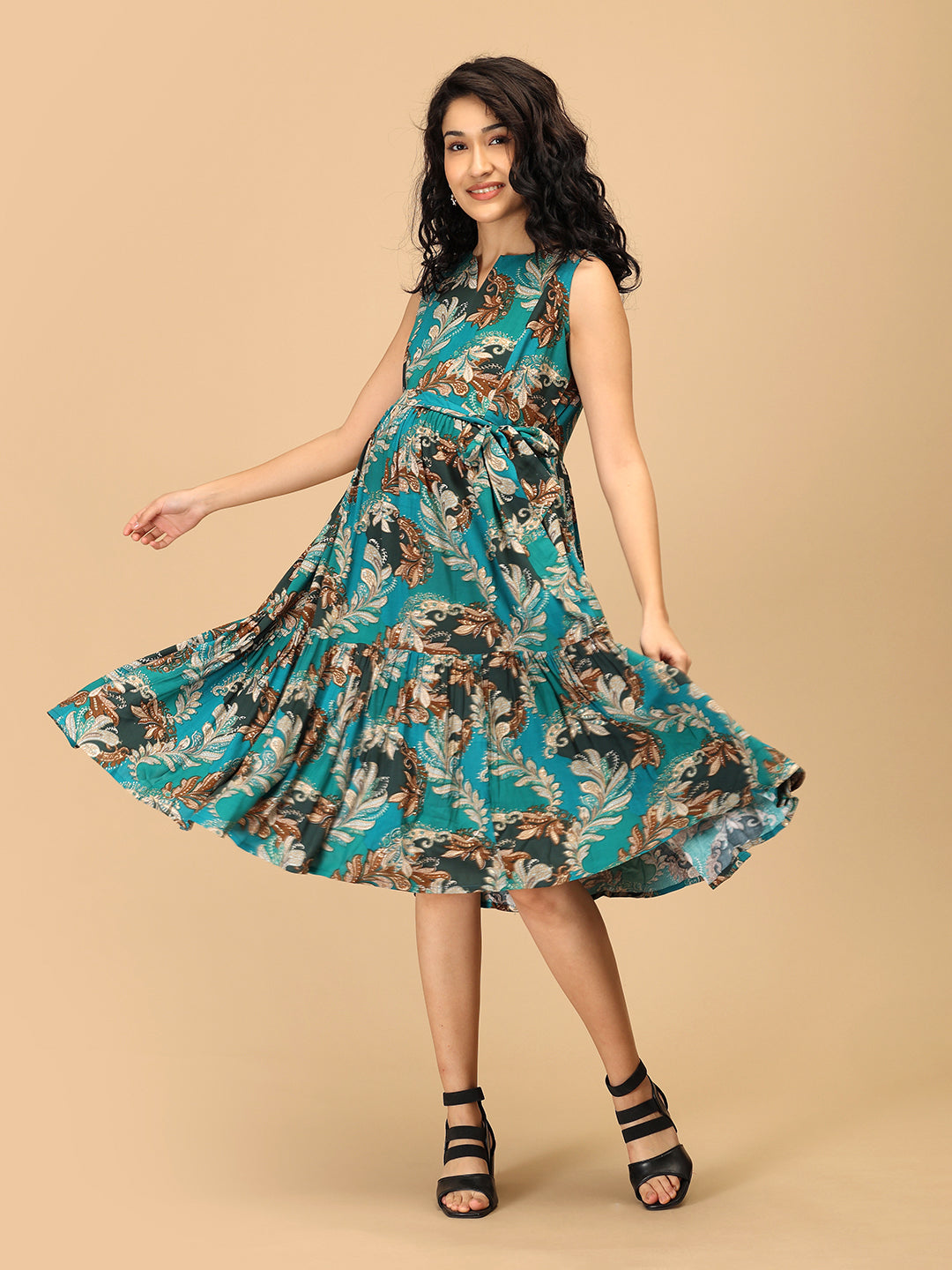 Woman twirling in teal tiered floral maternity and nursing dress