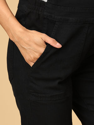 close up of a Model posing with her hand in pockets in The Mom Store black Denim Maternity Dungaree with Side Buttons 