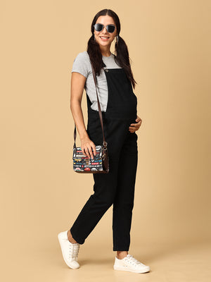 Side pose of pregnant woman in The Mom Store black Denim Maternity Dungaree with Side Buttons and sunglasses