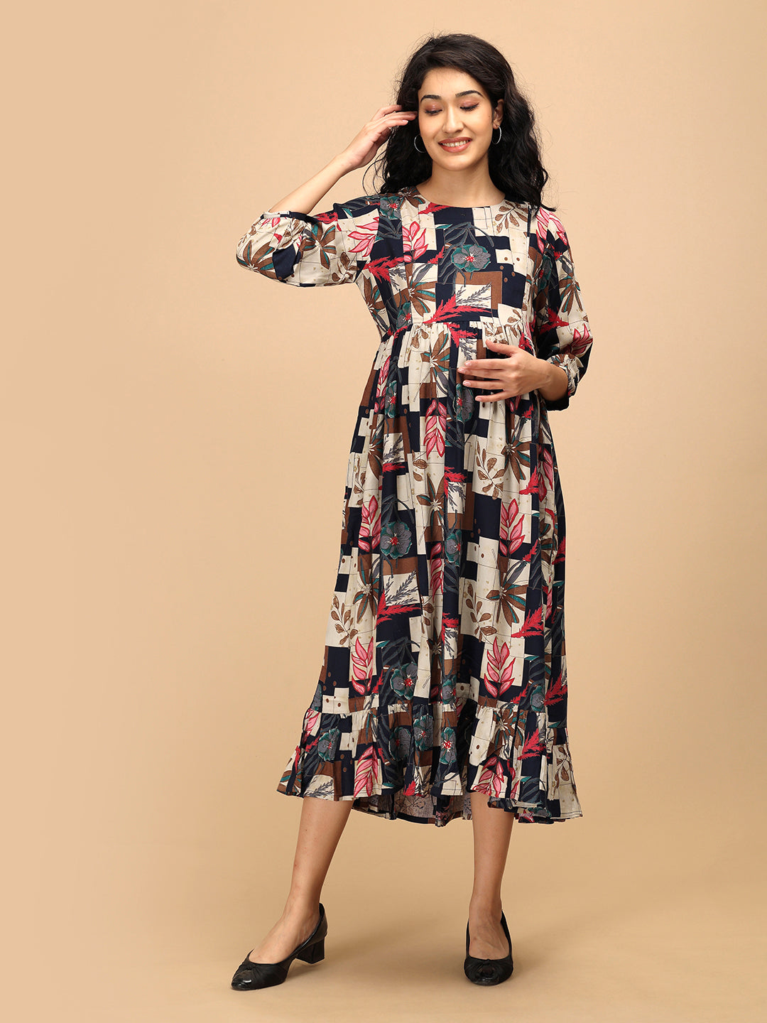 Pregnant woman in The Mom Store Muted Muse maternity and nursing dress with geometric floral print.
