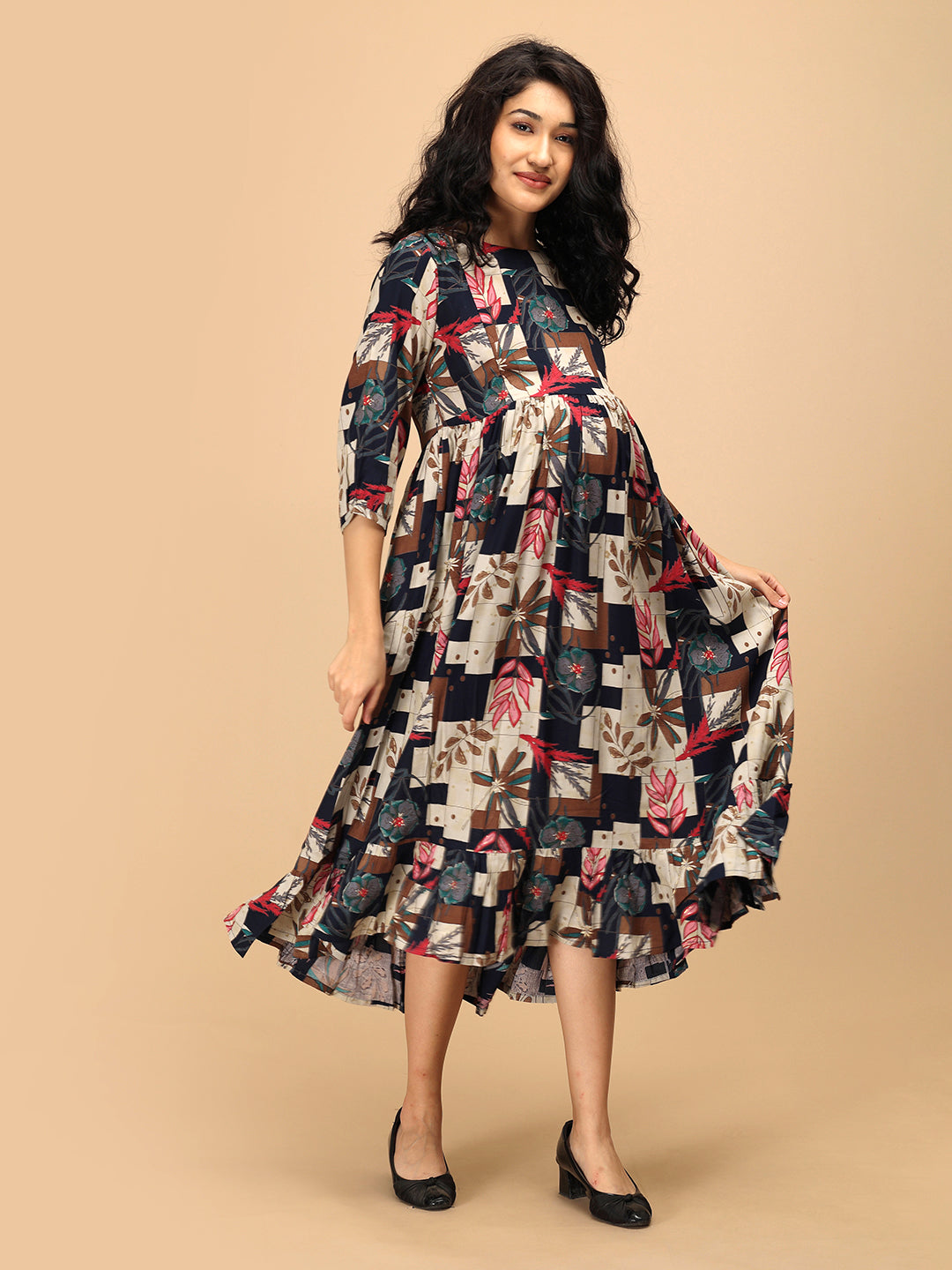 Woman twirling in The Mom Store Muted Muse maternity dress featuring vibrant patch-print design.