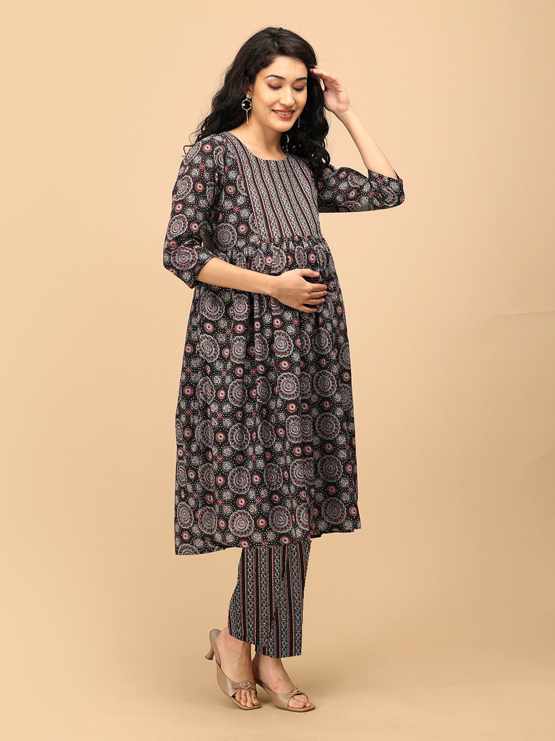 Pregnant woman wearing The Ajrakh Edit black printed maternity and nursing kurta set with straight pants, posing with hand on hair.
