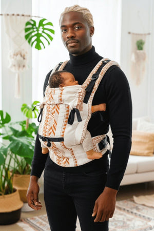 Father wearing Almitra Tattva unisex linen baby carrier with newborn in front carry, ergonomic hip support, adjustable straps, inclusive parenting babywearing carrier, sustainable and breathable fabric