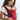 Front view of a smiling mother wearing the solid crimson red Almitra Tattva Aruna full-buckle baby carrier, securely holding her infant.