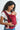 Front view of a smiling mother wearing the solid crimson red Almitra Tattva Aruna full-buckle baby carrier, securely holding her infant.