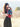Mother holding baby close in Almitra Tattva Kullu-inspired ergonomic baby carrier featuring bold tribal weave patterns in red, turquoise, black, and ochre tones, designed for inclusive babywearing, hands-free comfort, and secure front carry support outdoors.