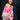 Mother carrying baby in Almitra Tattva Shubra woven baby wrap featuring bright pink geometric motifs and multicolor bohemian woven borders outdoors.