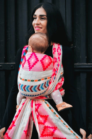 Bold inclusive baby carrier wrap supporting secure newborn carrying, parent child bonding, comfortable babywearing, and conscious modern parenting.