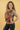 Happy caregiver wearing the Almitra Tattva Jataka Tales front-carry baby carrier with colorful traditional Indian art motifs and ergonomic support design. Inclusive babywearing carrier with adjustable straps, padded waist support, and comfortable fit for newborns, babies, and toddlers.