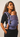 Three-quarter standing profile of a mother wearing the Almitra Tattva Nilopala geometric woven carrier with her infant resting inward.