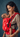 Side view of a mother looking affectionately at her baby in the red Shendur Ikkat carrier, highlighting the padded shoulder strap and black side webbing.