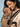 Tender close-up of a mother resting her forehead against her sleeping baby's face, showing the soft, folded neck support panel of the Tushi carrier.
