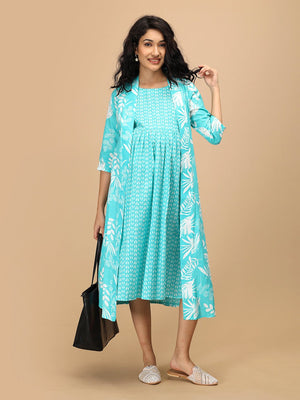 Model wearing an aqua blue printed maternity and nursing shacket dress, styled with a black tote bag.