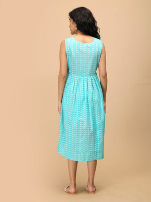 Back view of sleeveless aqua maternity and nursing dress with white all-over print and midi length.