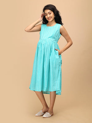 Angled front view of aqua printed maternity dress with flowy skirt and breathable fabric.