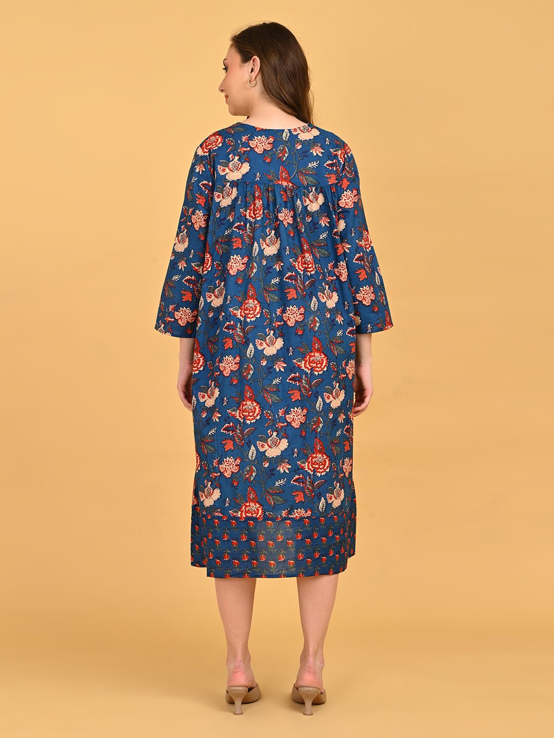 Back view of blue floral maternity midi dress with gathered yoke and loose silhouette.