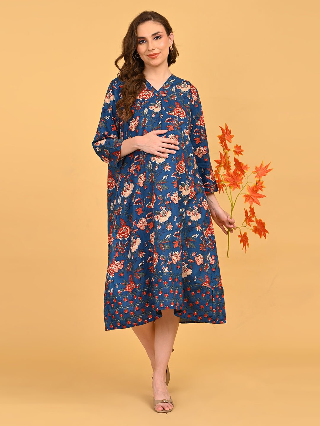 Front view of pregnant model in blue floral maternity dress with three-quarter sleeves and relaxed fit.