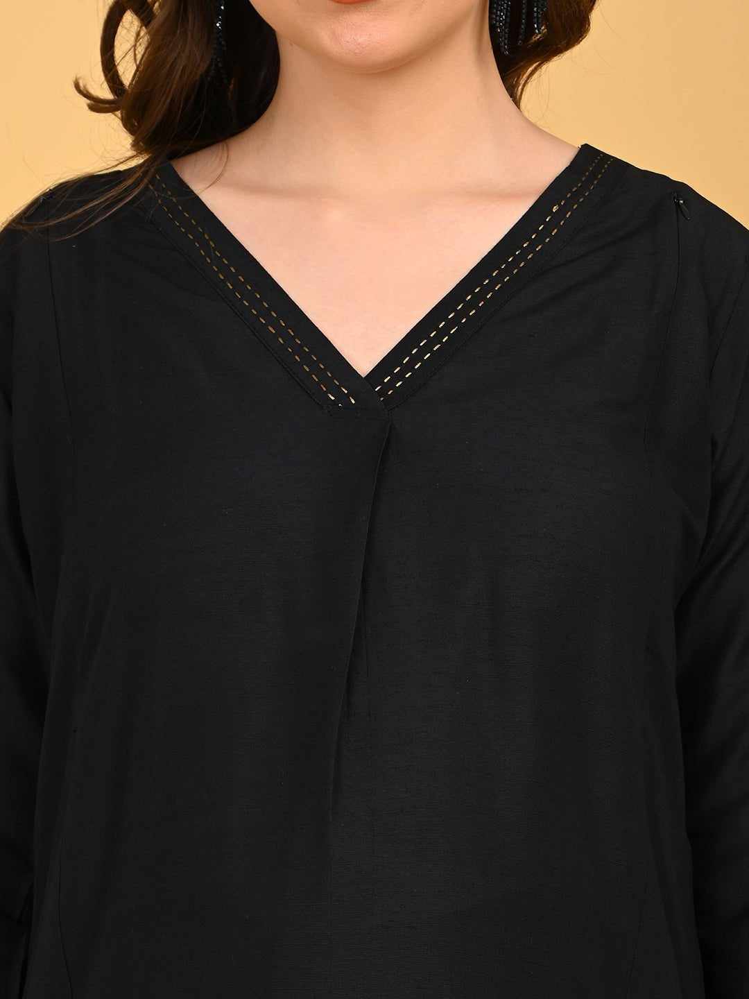 Close-up of black silk maternity kurta featuring V-neckline with subtle embroidered stitch detailing.