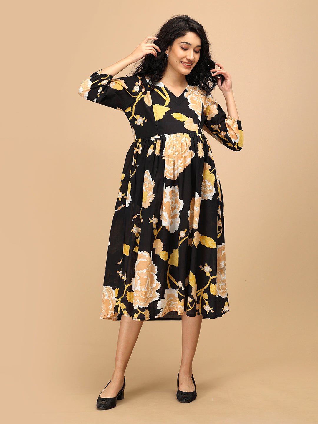 Pregnant model wearing Black Peony floral nursing dress with empire waist design.