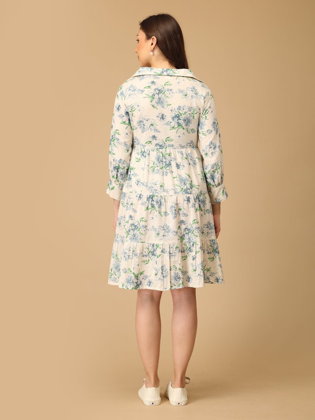 Woman wearing a floral dress on a beige background