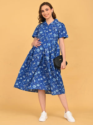 Model wearing Bluebell Beauty Maternity And Nursing Dress in blue floral print, front view with white sneakers