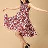 Woman wearing a red and white floral dress on a beige background