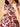 Woman wearing a sleeveless top with red and black floral pattern on a beige background