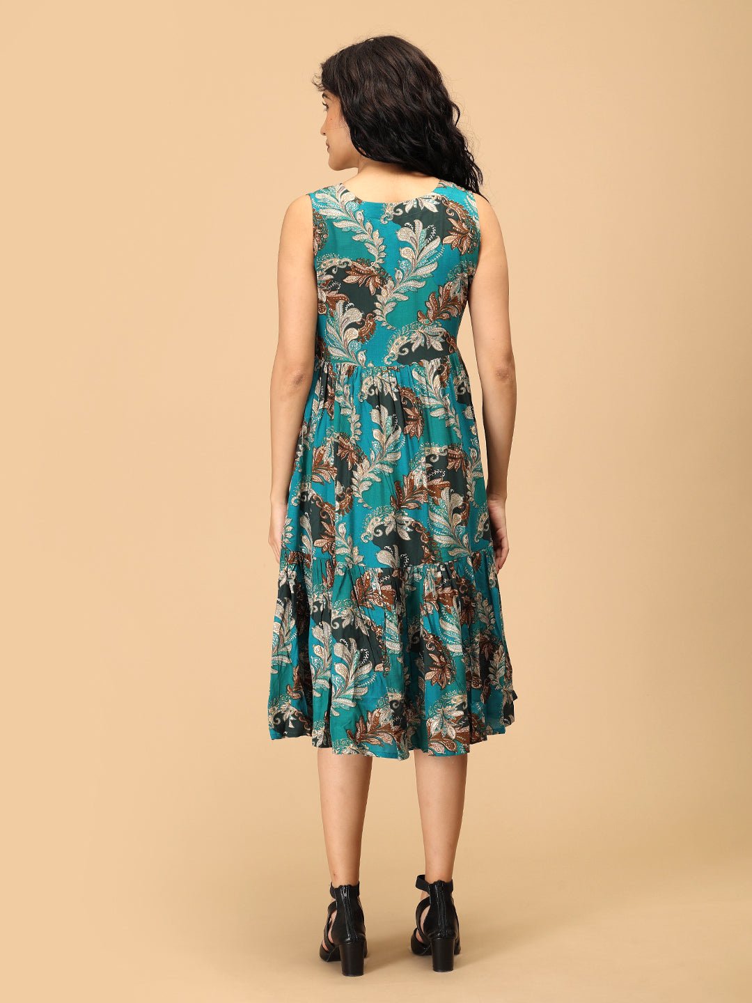 Back view of teal floral sleeveless maternity dress with tiered flowy skirt