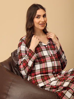 Pregnant model wearing Check Me In Maternity and Nursing Pajama Set from the mom store sitting on a bean bag