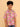 Child wearing a colorful patterned shirt and jeans on a beige background