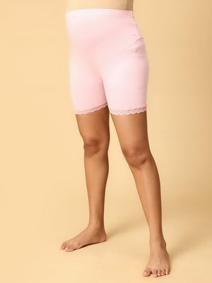 Model wearing pink coloured high waisted mama boyshorts from the mom store showing it's stretchability