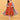 Pregnant model wearing Copper Daybreak maternity check dress with blue striped long shacket, walking in white sneakers.