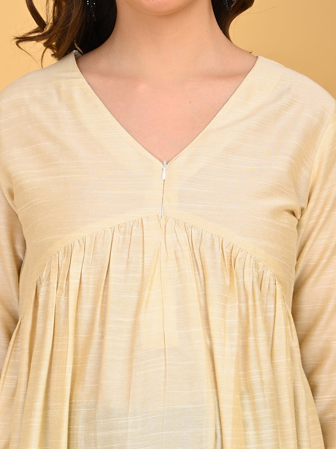 Close-up of cream silk maternity kurta featuring V-neckline and concealed nursing zipper.