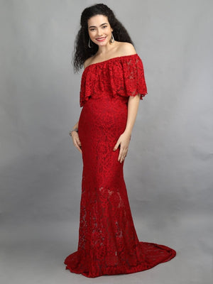 A visibly pregnant model wearing wine coloured, off-shoulder maternity maxi dress from The Mom Store .