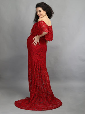 Playful back pose of a pregnant lady wearing wine coloured, off-shoulder maternity maxi dress from The Mom Store, touching her bump.