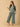 The Mom Store Evergreen Ease green maternity pajama set with relaxed wide-leg pants, model reading a book.