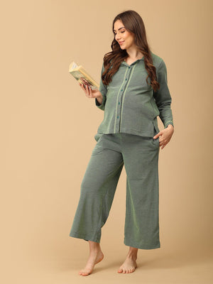 The Mom Store Evergreen Ease green maternity pajama set with relaxed wide-leg pants, model reading a book.
