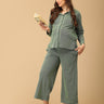 The Mom Store Evergreen Ease green maternity pajama set with relaxed wide-leg pants, model reading a book.