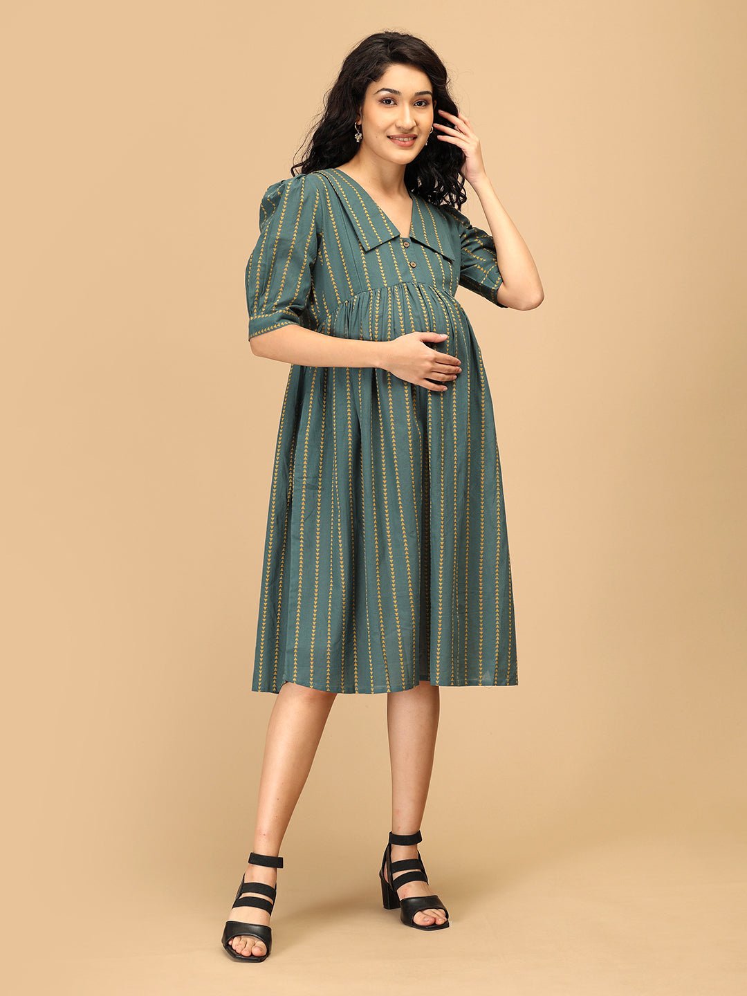 Smiling woman wearing The Mom Store green striped Everyday Ease maternity and nursing dress.