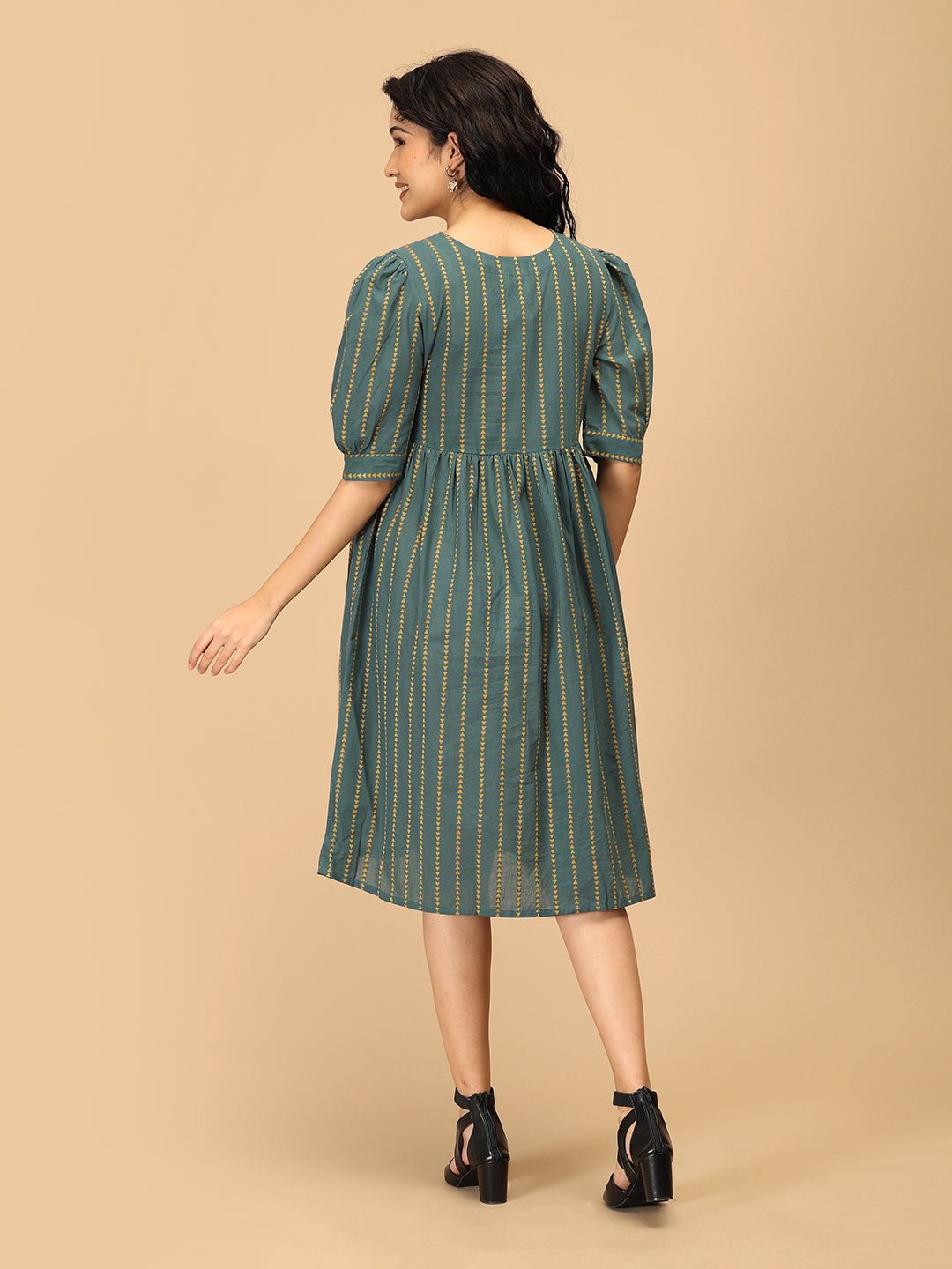 Back view of The Mom Store Everyday Ease green maternity dress with puff sleeves and striped print.
