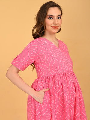 Flamingo Flirt Maternity and Nursing Dress in pink with geometric print, V-neck and short sleeves, shown in a soft side profile.