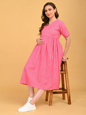 Flamingo Flirt Maternity and Nursing Dress in pink with all-over print, shown in a seated pose highlighting the bump-friendly fit.