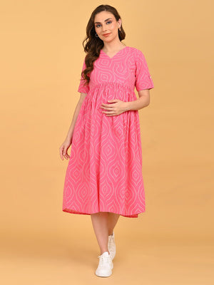 Flamingo Flirt Maternity and Nursing Dress in pink with geometric print, styled with white sneakers in a casual walking pose