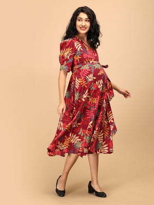 Woman walking in a garnet red floral maternity and nursing wrap dress with a flared midi silhouette.