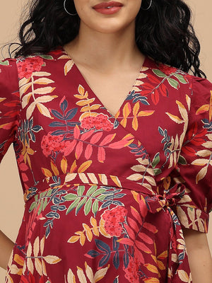Close-up of the V-neck wrap design on a garnet red floral maternity and nursing dress with leafy print.