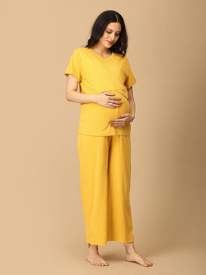 Pregnant Model wearing Golden Glow-Up Maternity and Nursing Nightwear Set from the mom store posing sideways and touching her belly