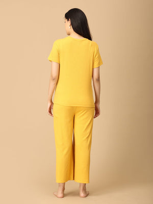 Pregnant Model wearing Golden Glow-Up Maternity and Nursing Nightwear Set from the mom store posing backwards