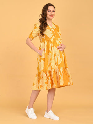Woman wearing Golden Lily Maternity And Nursing Dress in yellow floral print, front pose with hand in pocket