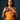 Woman facing forward wearing the bright mustard yellow Almitra Tattva Kasundi Ikkat baby carrier holding an infant centered against her chest.
