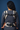 Back view of a woman wearing the Almitra Tattva Ajrakh baby carrier over a grey sweater, focusing on the horizontal structural back strap and secure center buckle connection.
